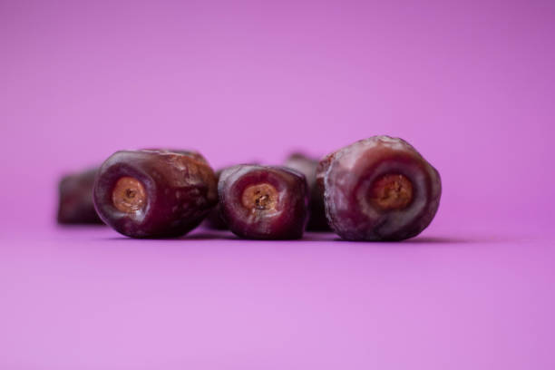 Close Up Dry Dates Fruit Isolated On Purple Background